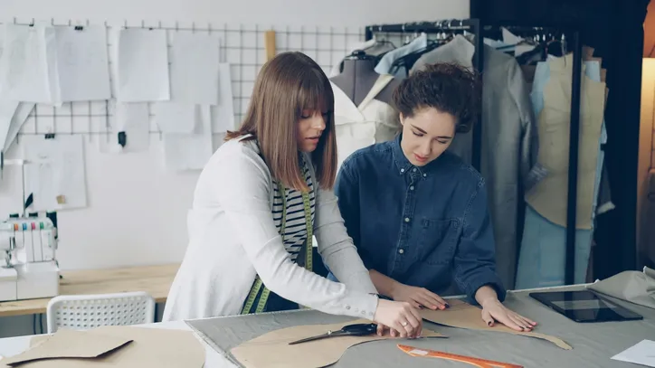 Atelier de confection : découpe de patrons sur la table de coupe